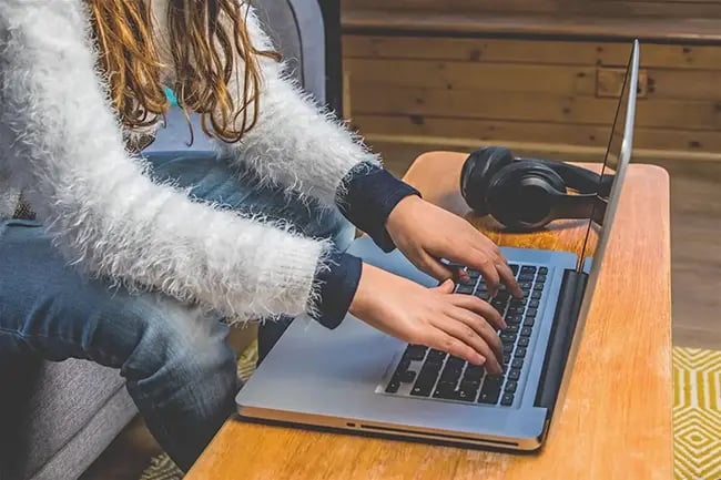 a woman typing on her laptop 