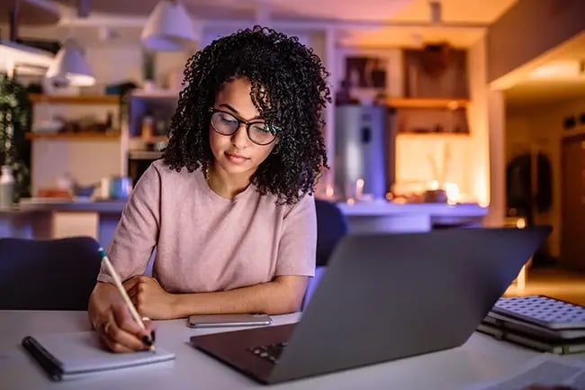 a young woman making notes at her desk