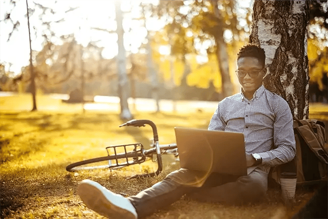 man sat on his laptop in the park