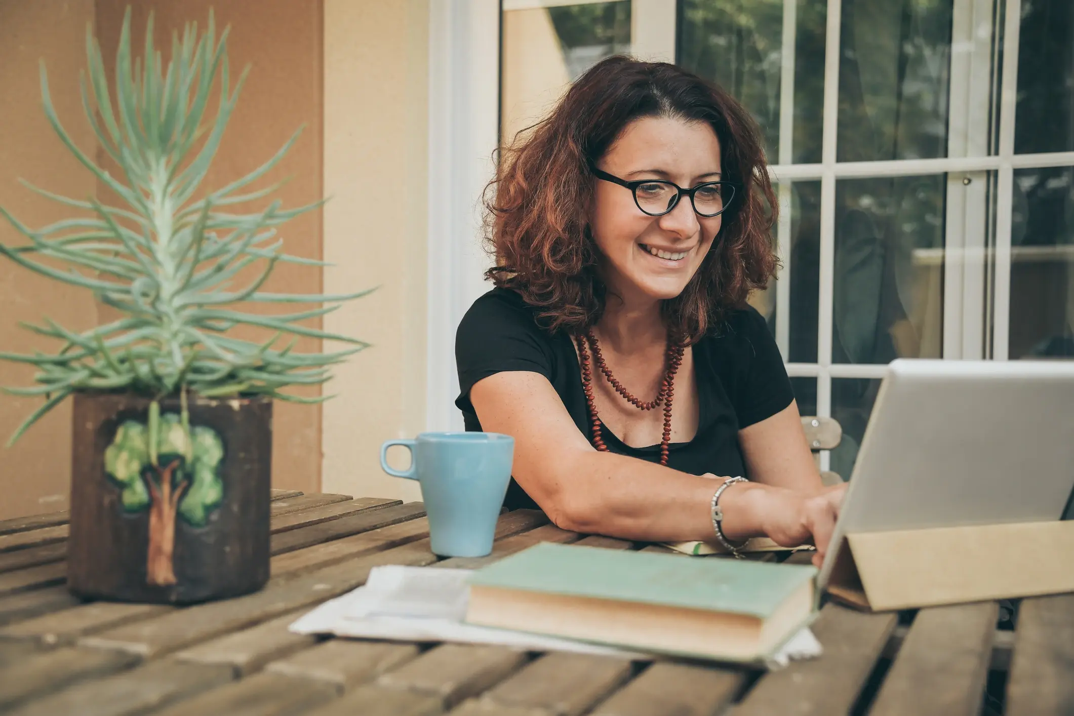 mature student working on her assignment outside on a laptop