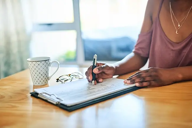 a woman sat a table writing something down