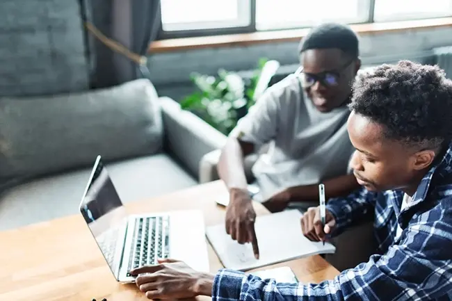 man helping his friend with coursework